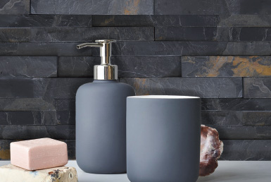 hermosas piedras naturales en ambiente de baño con dispensador de jabón y jarro azul