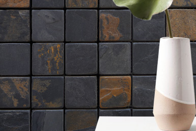 pared con revestimiento cerámico tipo piedra natural oscula y cobre con florero acabado tipo madera