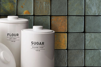 pared con acabado tipo piedra natural tonos verdes y cobre al frente recipientes blancos