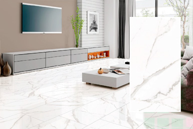 Cerámicas tipo marmol blanco con vetas negras, de fondo tenemos televisor y un cuadro, mesa de centro de sala blanco
