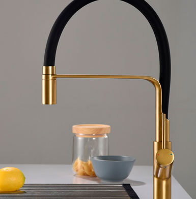 Llave para cocina dorada con negro con manivela para agua fria y caliente, diseño en tendencia curvo, limon amarillo y fondo blanco, accesorios de cocina