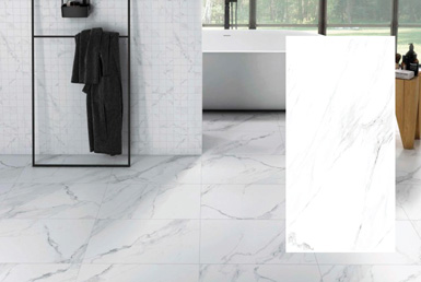 Porcleanato rectangular blanco con vetas negras en baño con pared decorativa de cuadros y pieza blanca de porcelanato