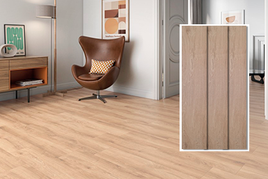 ESSENZA MIEL-porcelanato-tipo-madera Porcelanato maderado en piso con pared blanca y un cuadro de figuras, con un sillon café y almohada beige