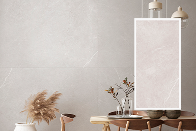 LAUREN BLANCO PORCELANTO Porcelanato gris en pared con pieza de porcelanato a lado y mesa con plantas decorativas